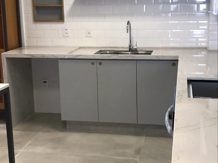 Cozinha planejada com bancada em pedra clara e armários cinza