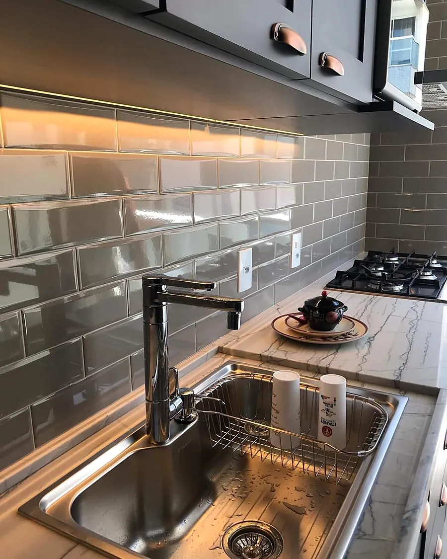 Cozinha com revestimento em metrô e iluminação sob o armário