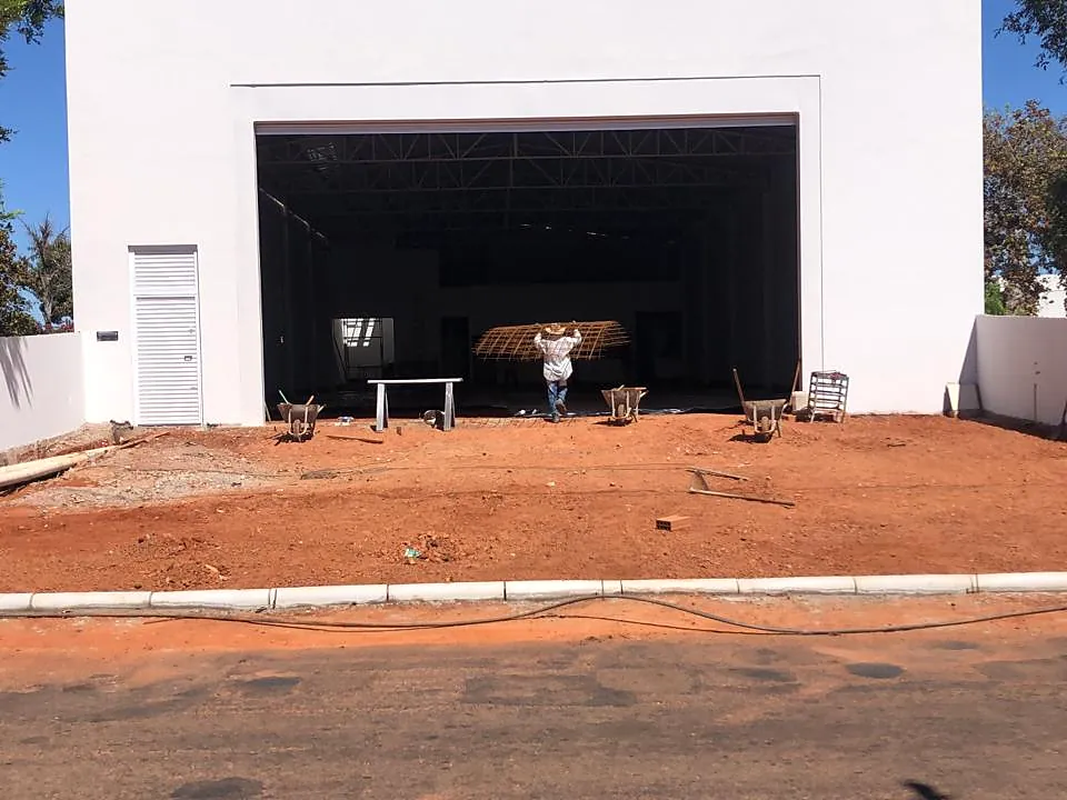 Fachada de galpão comercial concluída, com portão de acesso