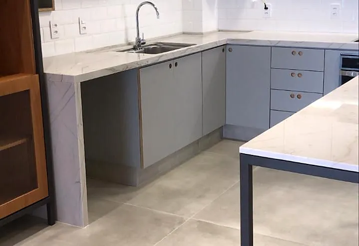 Cozinha planejada em L com bancada em pedra e prateleiras abertas