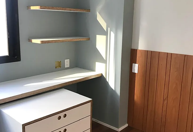 Ambiente renovado com marcenaria, prateleiras e piso de madeira